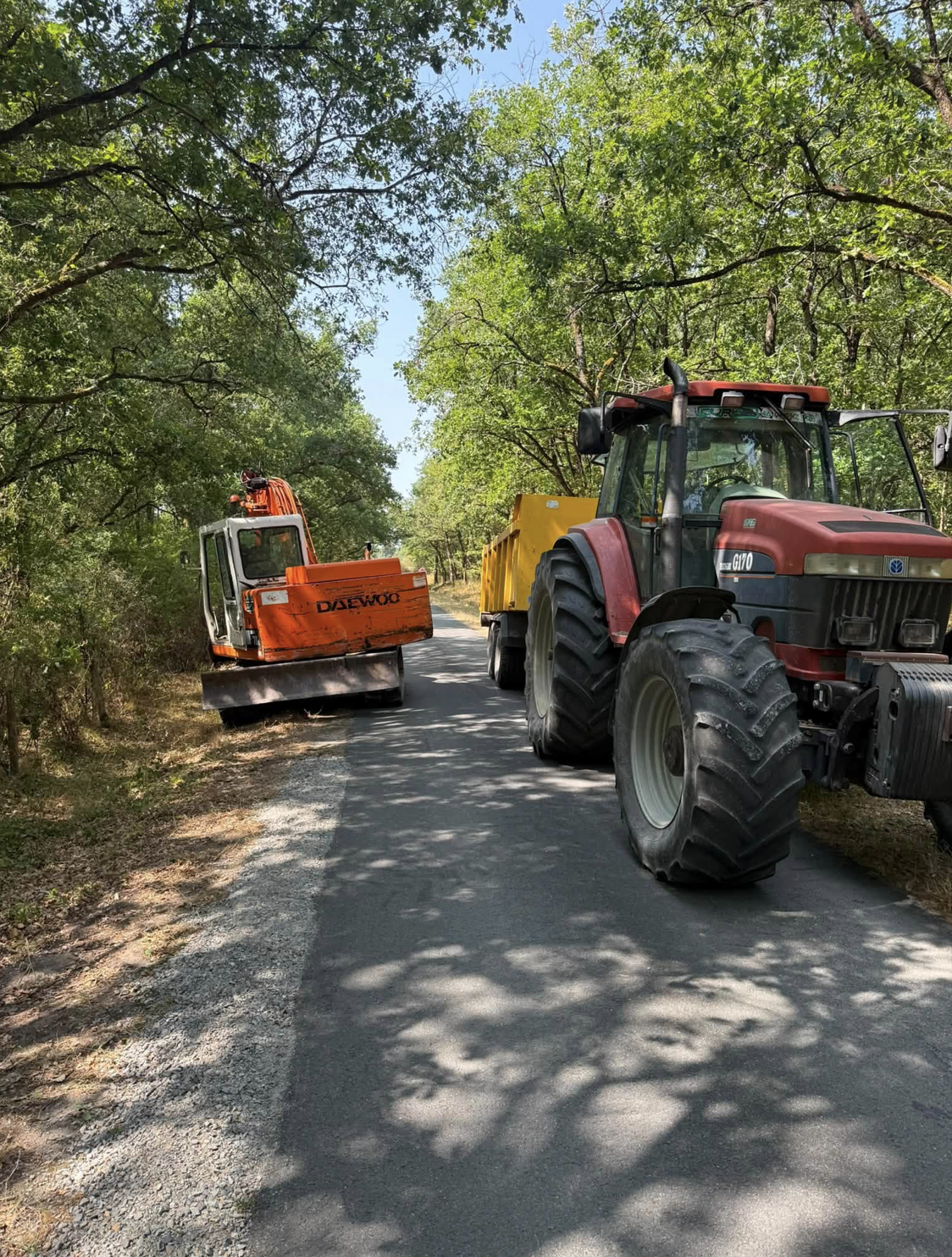 Tracteur et pelle mécanique sur route pour travaux publics